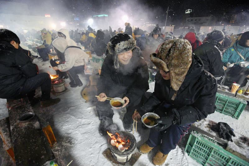 厳寒焼き肉まつり、北海道・北見　屋外、防寒着で七輪囲む