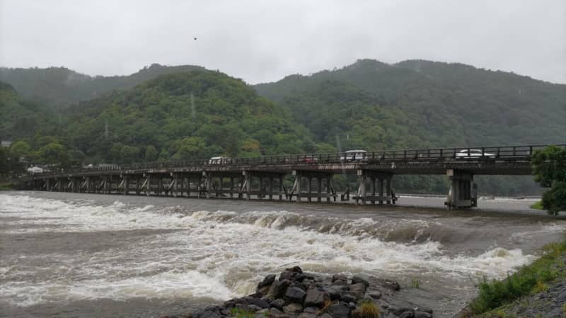 大雨で京都・嵐山の渡月橋は濁流に　修学旅行生「雨だけどテンション上げて」