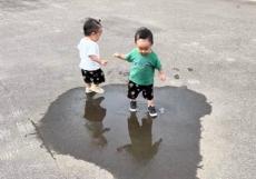 1歳双子が水たまりに遭遇→まったく同じタイミングで…「無敵の可愛さ」「完璧なシンクロ」