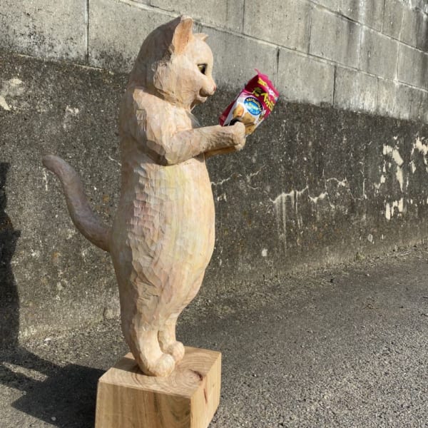 たべっ子どうぶつ見つめる木彫り猫 クスッと笑えるその正体はスマホ
