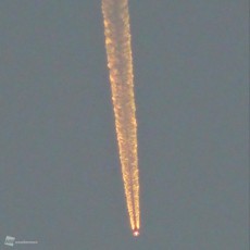 
夕焼けに輝く オレンジ色の飛行機雲
        